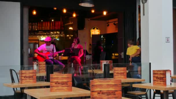 Joven hombre y mujer interpretan una canción en Warehouse en Clarke Quay en Singapur — Vídeo de stock