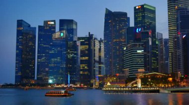 Turistik tekneler ve ışıklı modern Singapur mimarisi