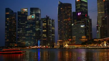 Turist teknesi ve ışıklı Marina Bay Finans Merkezi