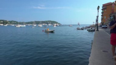 Villefranche-Sur-Mer'de gezinti ve mavi su üzerindeki insanlar