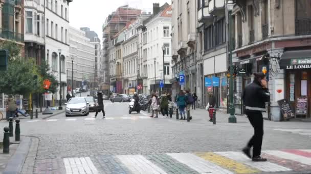 Joven con el teléfono cruza paso peatonal en Bruselas — Vídeos de Stock