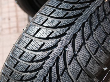 Lastik dükkanı yakınında güneşli bir sokakta yıkanmış lastikler