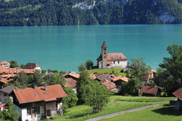 スイスのブリエンツにある古い教会と木製のシャレー ブリエンツ湖のターコイズブルーの水 — ストック写真