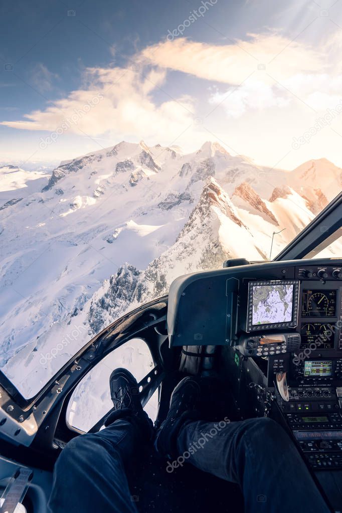 Helicopter cockpit with rear view of unrecognizable men co-pilot flying