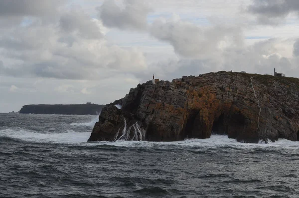 Rocky coastline with cliffs and waves. Sea waves hit the cliffs.