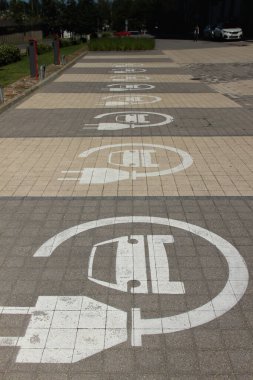 Sadece elektrikli arabalar için park yerleri. Şarj istasyonları sıraya dizildi. Elektrikli araba tabelası.