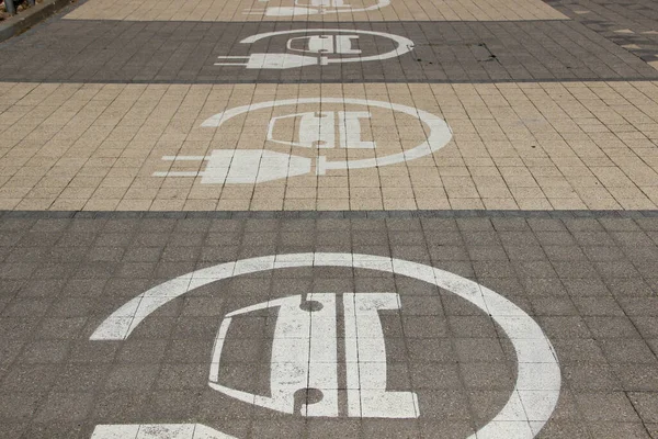 Sadece elektrikli arabalar için park yerleri. Şarj istasyonları sıraya dizildi. Elektrikli araba tabelası.