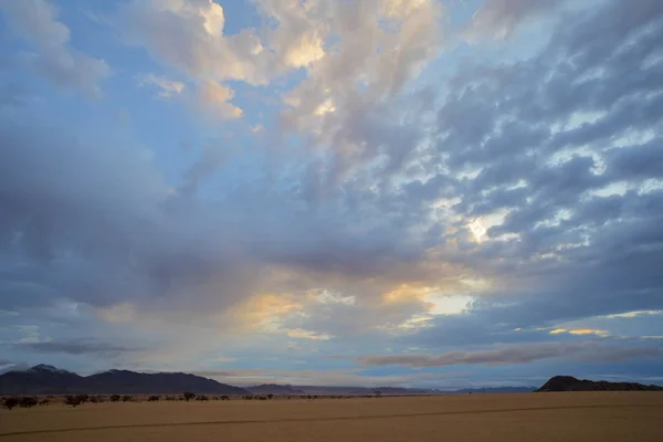 Nuvens ao nascer do sol sobre o deserto — Fotografia de Stock