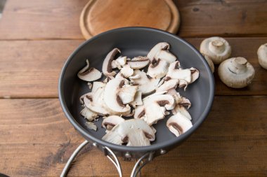 Pişirmek için şampiyon mantarları dilimliyorum.