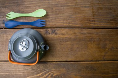 Turist gri çaydanlık, çatal ve kaşık masada duruyor.