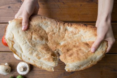 Pide ekmeği kıran kız, elleri ile kamp alanında piknik yapıyor.