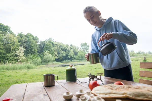 making tea or coffee in the campsite with a gas burner and gas cylinder