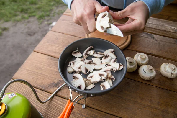Pişirmek için şampiyon mantarları dilimliyorum.