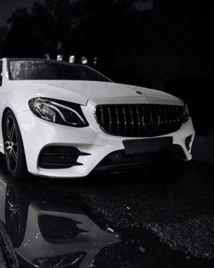Mercedes benz beyaz gece büyük bir su birikintisi yansıması ile