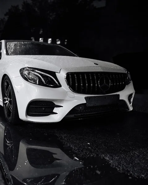 Mercedes benz beyaz gece büyük bir su birikintisi yansıması ile