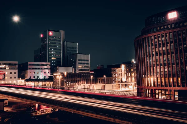 Geceleri Hannover şehrinin şehir manzarası ile bir köprü üzerinde sürüş araba ışık izleri