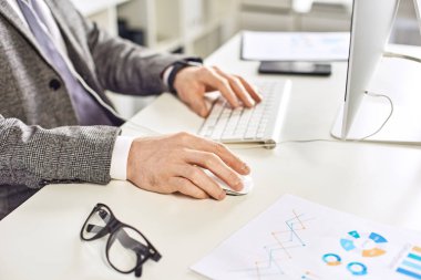 Ofiste bilgisayar üzerinde çalışan orta yaş işadamı