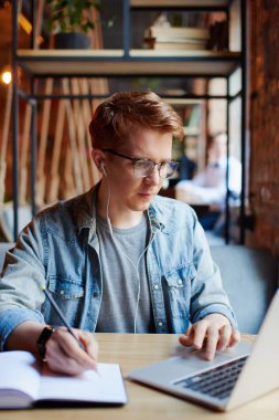 Ders kitabında not alan adam.