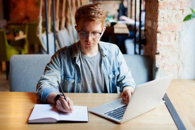 Ders kitabında not alan adam.