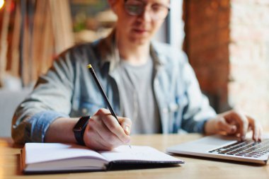 Ders kitabında not alan adam.