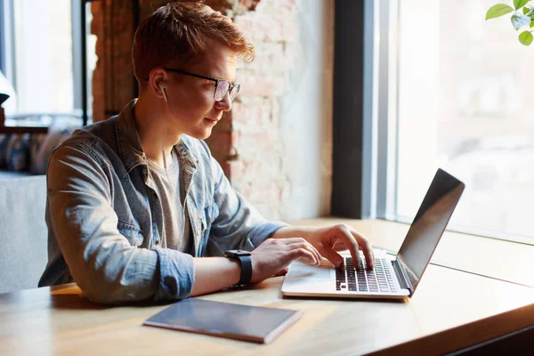 Jonge man werkt op de laptop in het café. — Stockfoto