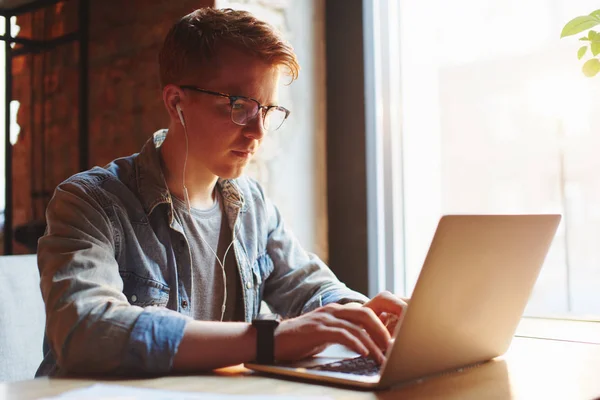 Jonge man werkt op de laptop in het café. — Stockfoto