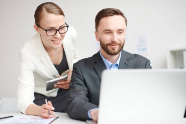 ofis çalışanları bir dizüstü bilgisayarda yeni bir proje tartışıyor