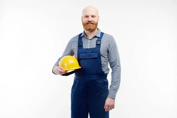 El ingeniero sostiene un casco de construcción en sus manos y mira a la cámara . — Foto de Stock