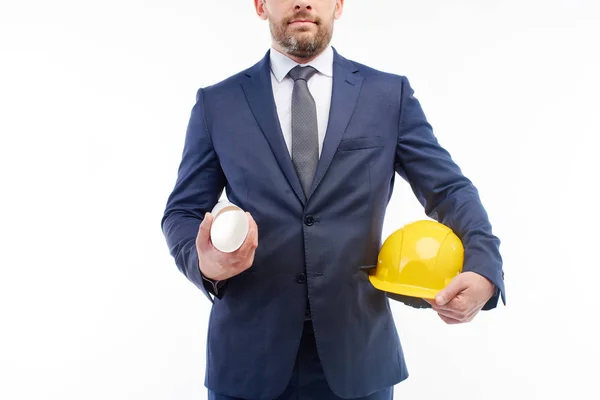 Foreman sosteniendo un casco de construcción y planos en sus manos . — Foto de Stock