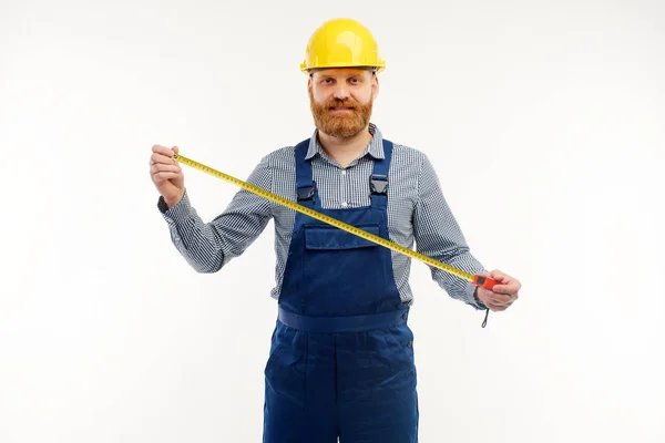 Ingeniero sosteniendo una cinta métrica sobre un fondo blanco . — Foto de Stock