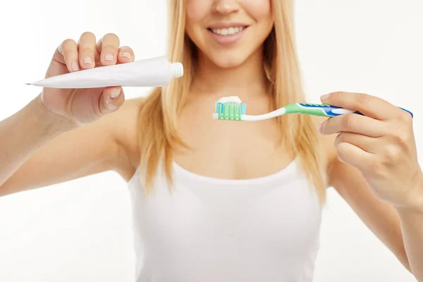 Primer plano. La niña utiliza artículos de higiene oral sobre un fondo blanco . — Foto de Stock