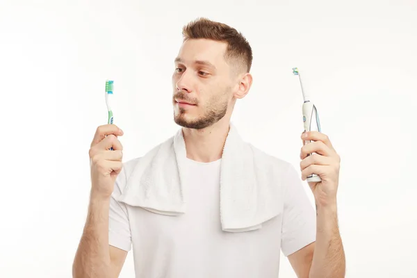 Man houdt twee tandenborstels in haar handen op witte achtergrond — Stockfoto