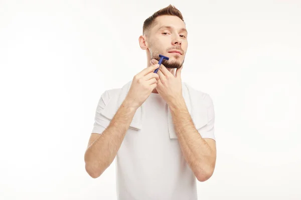 Knappe man scheren zijn baard op een witte achtergrond — Stockfoto
