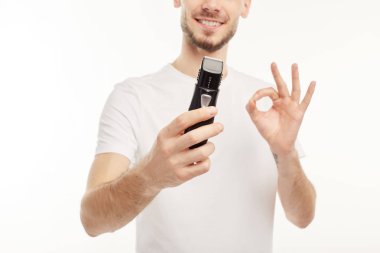 Closeup. Elinde sakal kesici tutan gülümseyen adam.