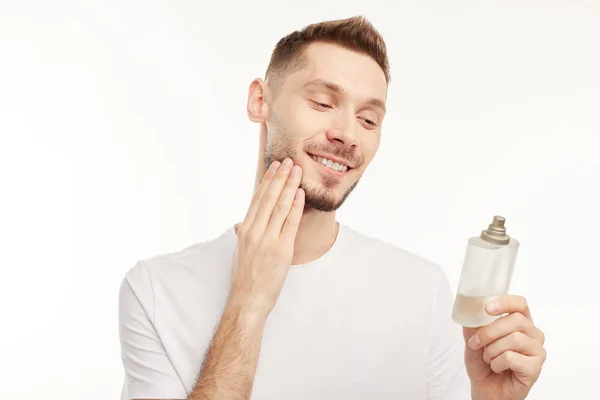 Lachende man het dragen van parfum op witte achtergrond — Stockfoto