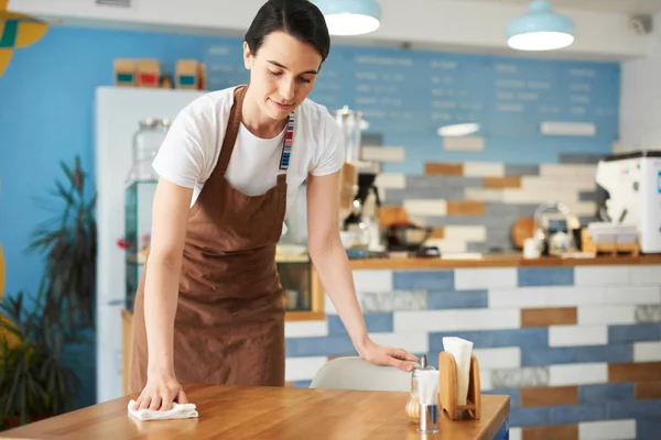 Orta yaş barista uzayda iş temizliği.