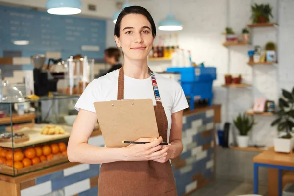 Barista önlük kameraya bakarak.