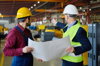 Mühendis ve foreman fabrikada yeni proje tartışıyorlar