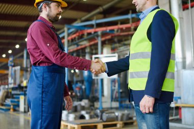Mühendis ve foreman başarıyla yeni bir proje tartışıldıktan sonra el sıkışmak.