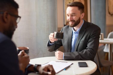 Kafede toplantı yapan iki iş adamı.