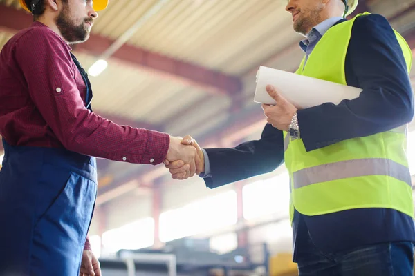 Ingenieur und Polier geben sich nach erfolgreicher Diskussion eines neuen Projekts die Hand. — Stockfoto