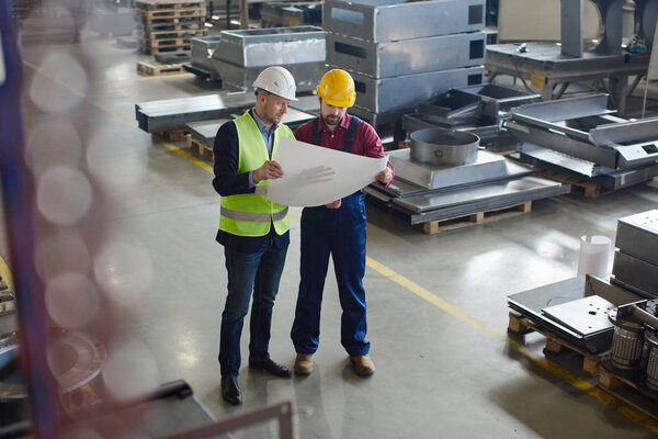 Brigadier explains to the engineer where to fix the drawings.