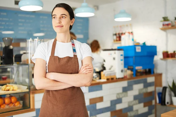Barista önlük kameraya bakarak.