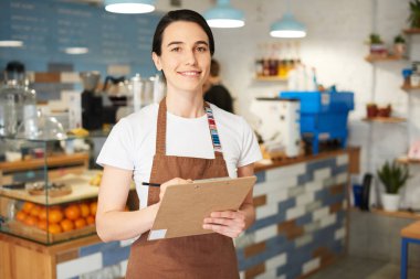 Barista önlük kameraya bakarak.