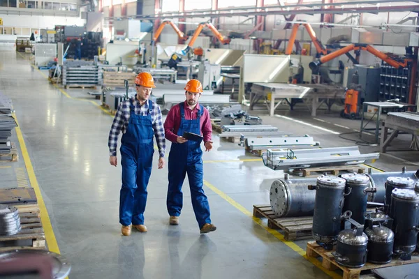 Ingenieros en sombreros duros que trabajan en la planta industrial . — Foto de Stock