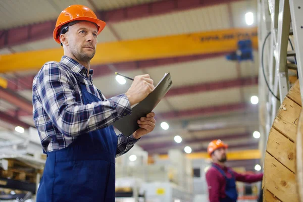Ingenieros en sombreros duros que trabajan en la planta industrial . — Foto de Stock