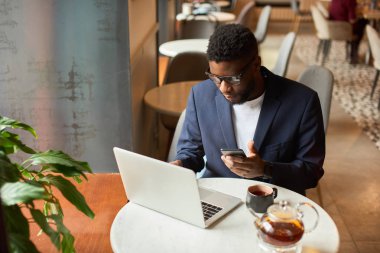 Afro-amerikan dizüstü çok özenle çalışıyor.