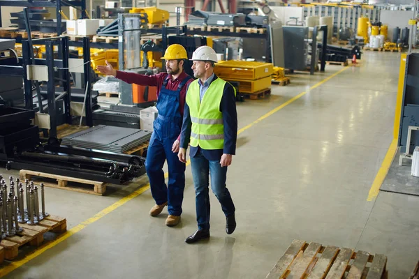 Ingenieros caminando a lo largo de la planta trabajan a tiro desde la distancia . — Foto de Stock