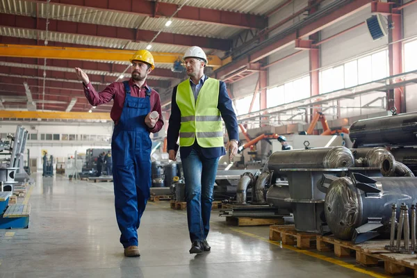 Ingegneri che camminano lungo lo stabilimento lavorano a colpo da distanza . — Foto Stock