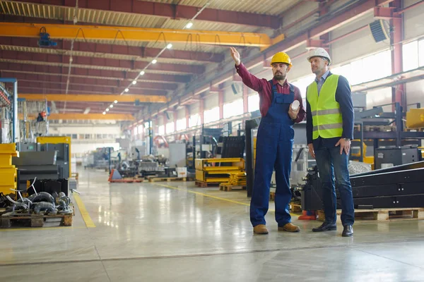 Ingenieros en sombreros duros que trabajan en la planta industrial . — Foto de Stock